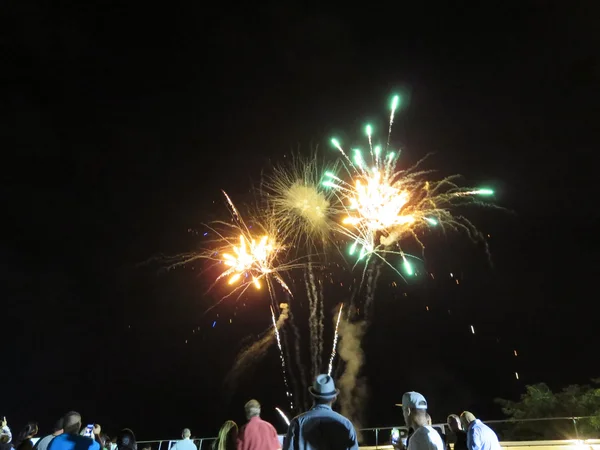 New Years Fireworks burst in the air as people watch display at
