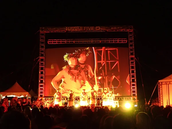 Hawaiian dancers stand on stage at night during the Hawaii 5-0 Television show season 5 premier