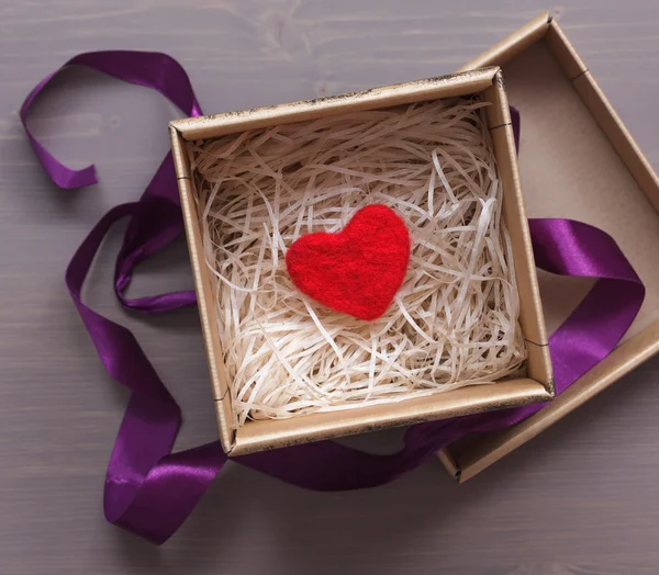 Celebratory box with a red woolen heart as a gift