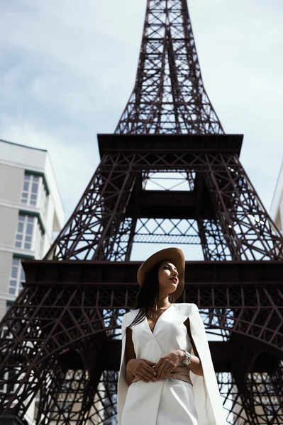 Raven haired indian lady posing against fake Eiffel Tower