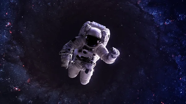 An astronaut floats above billions of stars. Stars provide the background. Elements of this Image Furnished by NASA.
