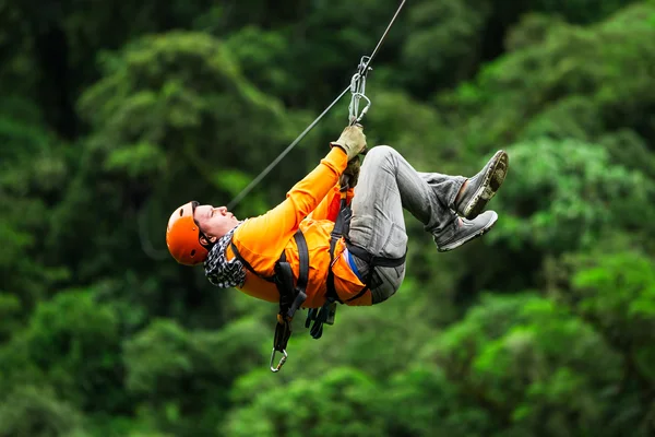 Orange Dressed Tourist On Zip Line Against Forest