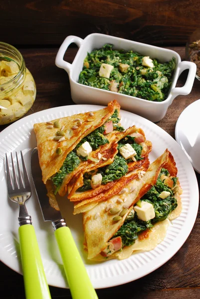 Spinach and feta filled pancakes on wooden table