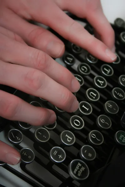 Hands typing on an old typewriter
