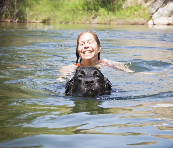 Girl and lab dog swimming