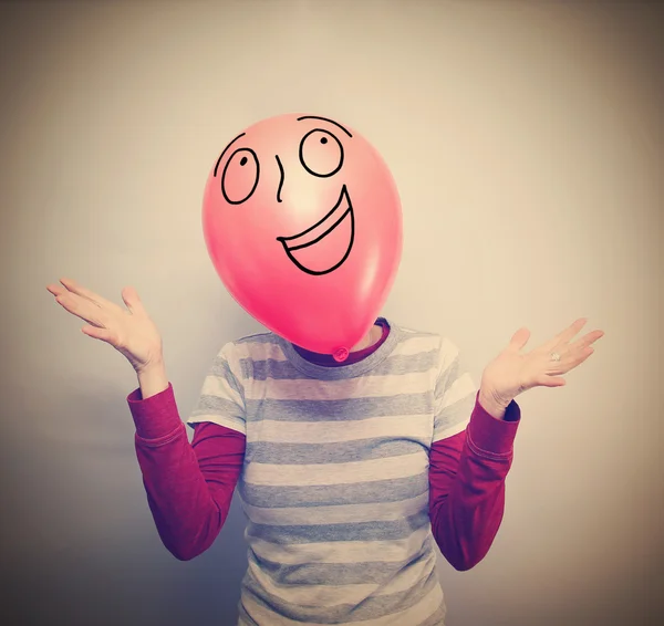 Person with balloon in front of face