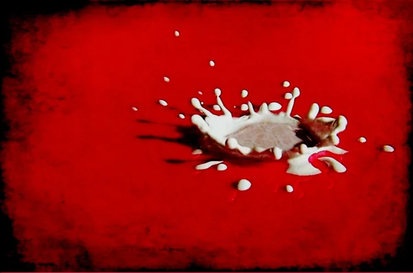 Milk drop on red surface