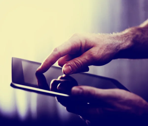 Hands typing on a tablet