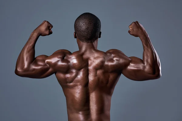 Black african male with well defined muscular body back posing in studio
