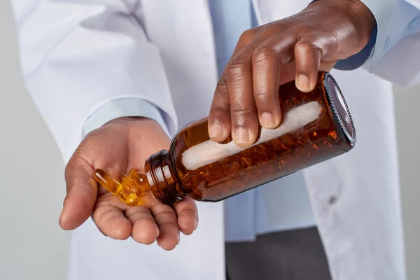 Doctor holding pills for cure of illness