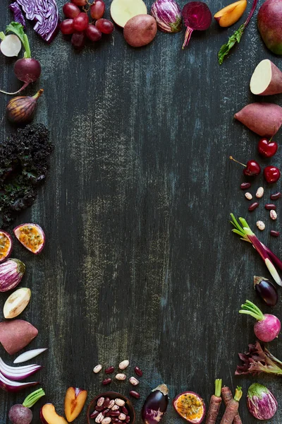 Border of fruits and vegetables on dark background