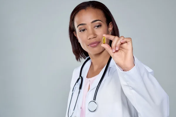 Female doctor holding up breakthrough drug cure pil