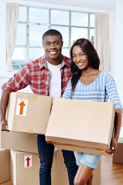 African couple moving boxes into new home