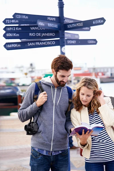 Couple on travel holiday at sign