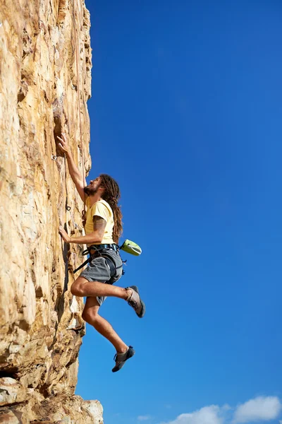 Rock climbing man reaching for grip