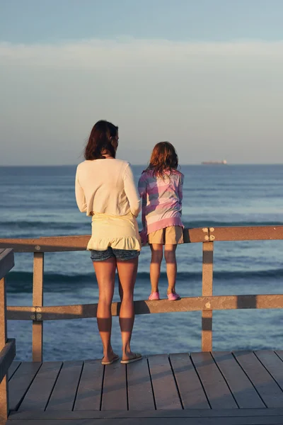 Mom and daughter looking at ocean