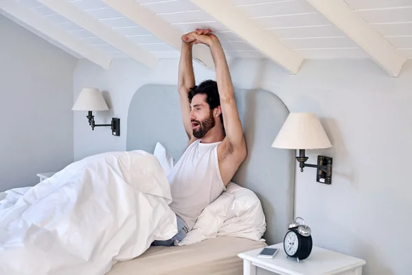 Man stretching arms after waking up