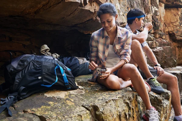 Couple sitting by cave taking break