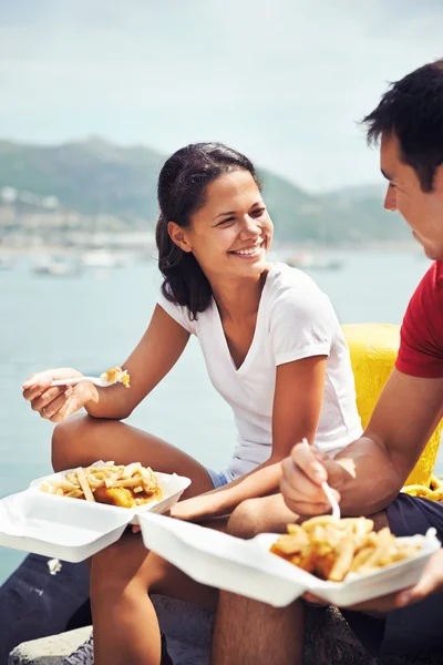 Woman and partner eat fish and chips