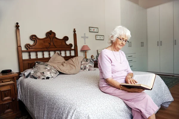 Woman on bed reading book