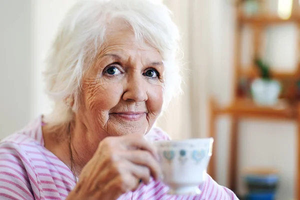 Old lady holding cup of tea