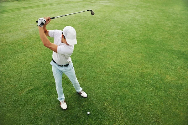 Golfer hitting golf ball