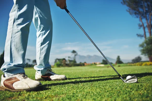 Golfer with iron hitting tee shot