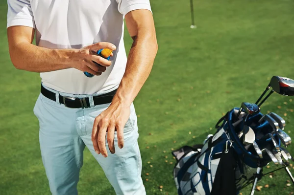 Golf sport man with sunblock lotion spray