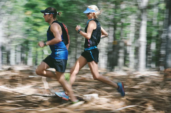 Couple running fast through forest