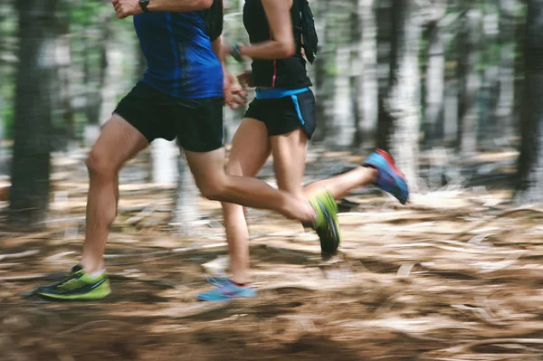Couple running fast through forest
