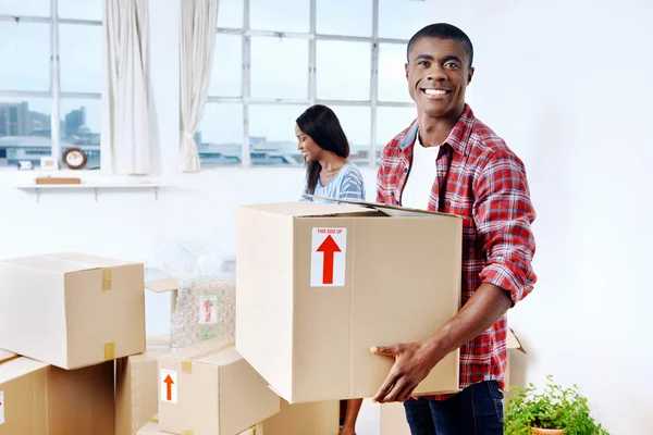 Couple moving boxes into new home