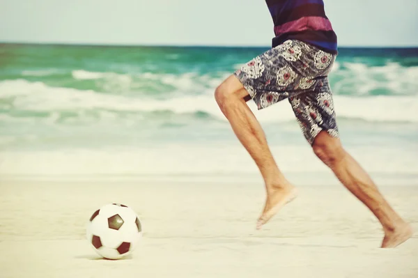 Brasil man playing soccer on beach