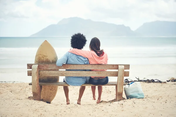 Couple sitting on bench at beach