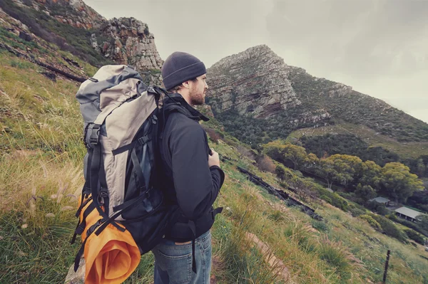 Man hiking wilderness mountain with backpack