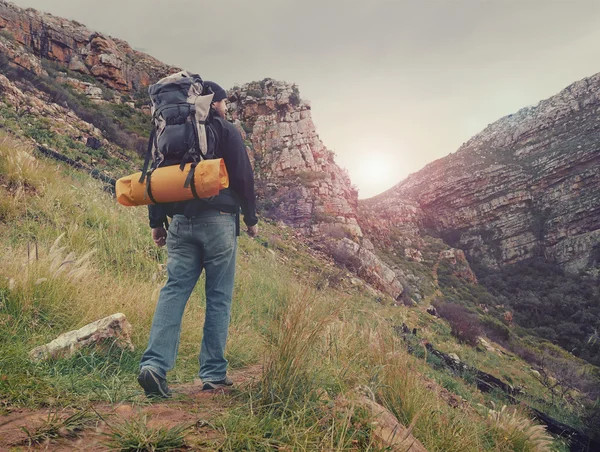 Man hiking wilderness mountain with backpack