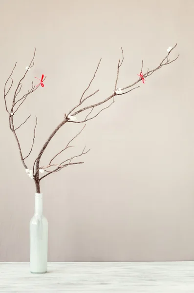 Bare branch in white vase on table top