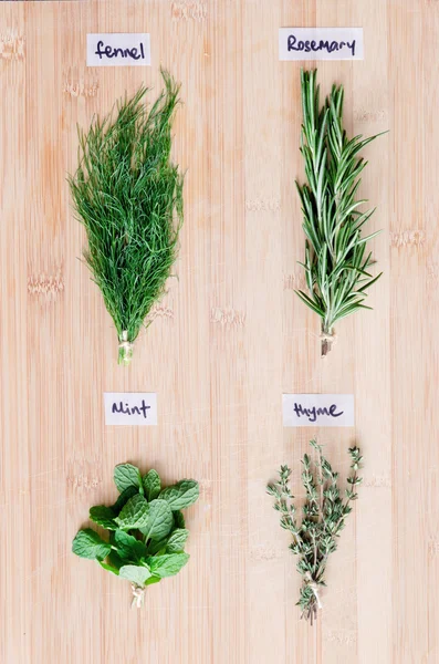 Fresh herbs with names on wooden board