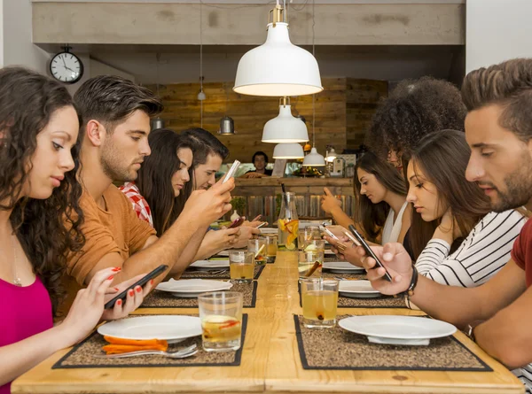 Friends at a restaurant  occupied with cellphones