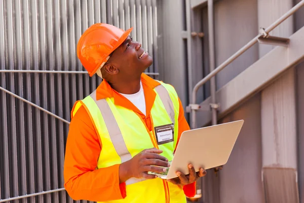 Engineer using laptop in substation