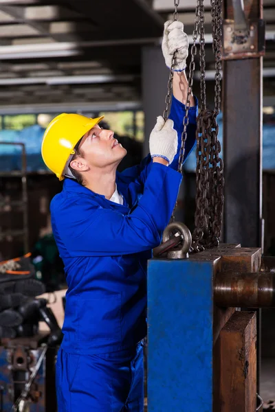 Worker pulling chains