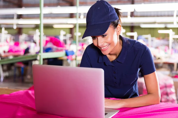 Female factory worker using laptop