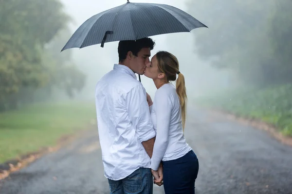 Couple in love under umbrella in the rain