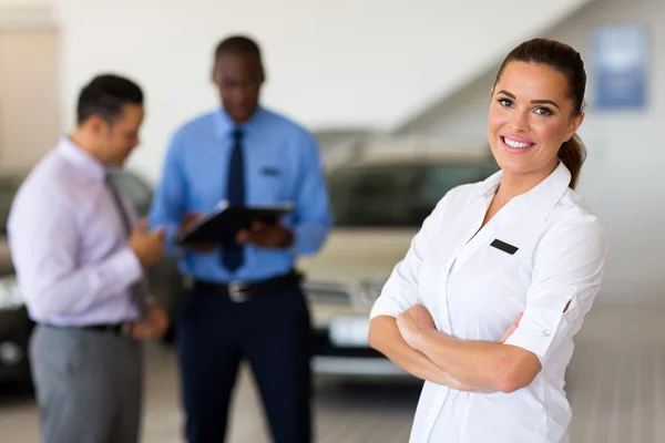 Female vehicle sales consultant standing in showroom
