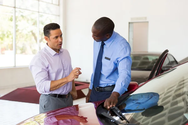 Man talking to african car salesman