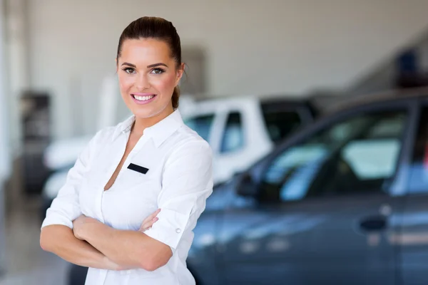 Female car dealer with arms crossed