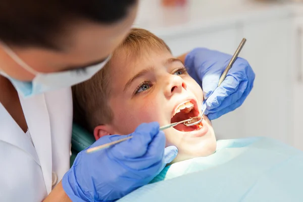 Dentist examining boys teeth