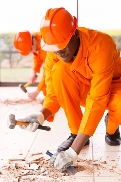 Builders removing old floor tiles