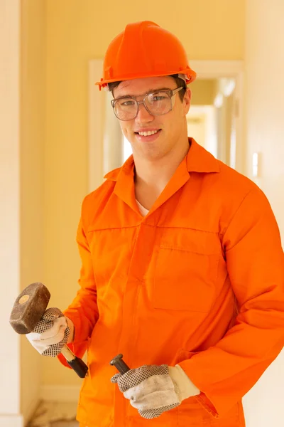 Builder holding chisel and hammer