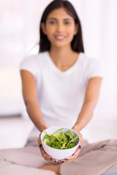 Woman presenting healthy green salad