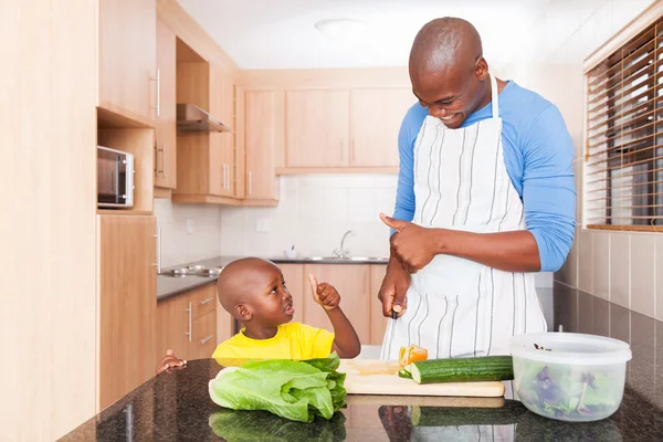 Father and son cooking in kitchen